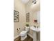 Stylish powder room with pedestal sink and wood floor at 7563 Saguaro Cactus Ave, Las Vegas, NV 89178