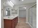 Double vanity bathroom with wood cabinets, shower, and tub at 7564 Daniel Boone Ct, Las Vegas, NV 89166