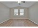 Bright bedroom with wood-look floors, ceiling fan, and large windows at 7564 Daniel Boone Ct, Las Vegas, NV 89166