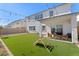 Spacious backyard featuring artificial grass, a covered patio, and a play structure at 8990 Rolling Pietra St, Las Vegas, NV 89166