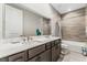 Double vanity bathroom with a large mirror and bathtub at 8990 Rolling Pietra St, Las Vegas, NV 89166