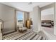 Well-lit bedroom with a rocking chair, dresser, and access to another room at 8990 Rolling Pietra St, Las Vegas, NV 89166