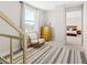 Cozy upstairs hallway with a rocking chair, dresser, and view into the main bedroom at 8990 Rolling Pietra St, Las Vegas, NV 89166