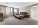 Spacious main bedroom with a wood platform bed and large windows at 8990 Rolling Pietra St, Las Vegas, NV 89166