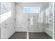 Large walk-in shower with marble tile and a built-in seat at 8990 Rolling Pietra St, Las Vegas, NV 89166