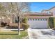 One-story house with tan walls, white garage door, and landscaping at 9272 Cantana St, Las Vegas, NV 89123