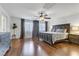 Main bedroom with wood floors, large bed, and ceiling fan at 1313 Alamosa Ridge Ct, North Las Vegas, NV 89084