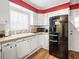 White cabinets and black appliances in this corner kitchen at 1709 S 6Th St, Las Vegas, NV 89104