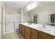 Well-lit bathroom with double sinks, vanity, and a glass enclosed shower at 2538 Capella Star St, Henderson, NV 89044