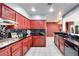 Modern kitchen with red cabinets and granite countertops at 256 Garfield Dr, Henderson, NV 89074