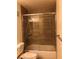 A bathroom featuring a shower-tub combo with sliding glass doors and tile surround at 2725 S Nellis Blvd # 1201, Las Vegas, NV 89121