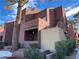 Two-story building with Spanish-style architecture, landscaping, and a tree at 4050 Pacific Harbors Dr # 133, Las Vegas, NV 89121