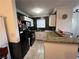 Galley-style kitchen with granite countertops and black appliances at 4050 Pacific Harbors Dr # 133, Las Vegas, NV 89121