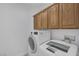 Laundry room with light cabinets above a newer washer and dryer at 4917 Teal Petals St, North Las Vegas, NV 89081