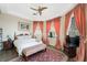 Bright bedroom with wooden floors, decorative rug, ceiling fan, and pink curtains for a warm and inviting atmosphere at 7192 Polita Ct, Las Vegas, NV 89156
