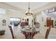 Elegant dining area with glass-top table and wood chairs, offering views into the living room at 7192 Polita Ct, Las Vegas, NV 89156