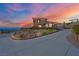 Luxury home with a long driveway and beautiful sunset in the background at 7192 Polita Ct, Las Vegas, NV 89156