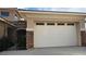 Attached two-car garage featuring a white door with decorative stonework and gated front courtyard entry at 7192 Polita Ct, Las Vegas, NV 89156