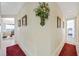 Long hallway with red carpet runner and artwork on the walls at 7192 Polita Ct, Las Vegas, NV 89156