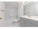 Updated bathroom with gray vanity, white toilet and bathtub at 1013 Falconhead Ln # 101, Las Vegas, NV 89128