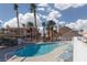 Community pool with lounge chairs and palm trees at 1013 Falconhead Ln # 101, Las Vegas, NV 89128