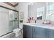 Modern bathroom with a walk-in shower, gray vanity, and pink tile accents at 10262 Super Jovian St, Las Vegas, NV 89143