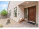 Front entry with a wooden bench and small water feature at 10262 Super Jovian St, Las Vegas, NV 89143