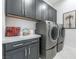 Bright laundry room with gray cabinets and stainless steel appliances at 10262 Super Jovian St, Las Vegas, NV 89143