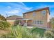 View of backyard showcasing two story home with covered patio at 10597 Painted Bridge St, Las Vegas, NV 89179