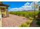 View of the backyard's brick paved patio and lovely landscaping with a beautiful mountain backdrop at 12457 Heritage Bend Dr, Las Vegas, NV 89138