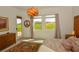 Sunlit bedroom with large windows, a cozy bed, stylish dresser and views of the outdoors at 12457 Heritage Bend Dr, Las Vegas, NV 89138