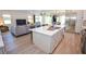 Modern open concept kitchen and living room with a large island, stainless steel appliances, and wood flooring at 12457 Heritage Bend Dr, Las Vegas, NV 89138