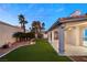 Artificial turf backyard with covered patio and palm trees at 1613 Shadow Rock Dr, Las Vegas, NV 89117