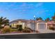 Front view of the house with two-car garage and landscaped yard at 1613 Shadow Rock Dr, Las Vegas, NV 89117