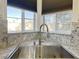 Stylish kitchen sink with granite countertops and natural light from the windows above at 1830 N Buffalo Dr # 2095, Las Vegas, NV 89128