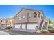 Tan two-story condo building with attached garages and stairs at 2101 Quartz Cliff St # 207, Las Vegas, NV 89117