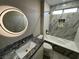 Bathroom with a round mirror, granite vanity, and bathtub at 2620 Silverton Dr, Las Vegas, NV 89134