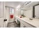 This is a bright bathroom with double sinks, large mirror, and wood-look floors at 2668 Alwoodley Cir, Las Vegas, NV 89142