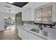 Kitchen with white cabinets, stainless steel sink, and green accent wall at 3883 Seedling Way, Las Vegas, NV 89115