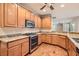 Modern kitchen with wood cabinets, granite counters, and stainless steel appliances at 5124 Pensier St, Las Vegas, NV 89135