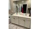 Double vanity bathroom with modern fixtures and a large mirror at 6306 Orions Belt Peak St, North Las Vegas, NV 89031