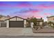 Single-story home with a two-car garage and landscaped front yard at 7134 Grasswood Dr, Las Vegas, NV 89147