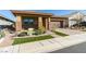 Tan house with a brown garage door and well-manicured lawn at 752 Drammatico Pl, Henderson, NV 89011