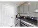 Bright laundry room with modern LG washer and dryer, and gray cabinets at 9542 Gainey Ranch Ave, Las Vegas, NV 89147