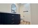 Modern bathroom with dark vanity and arched mirror at 10173 Grants Arbor Rd, Las Vegas, NV 89183