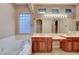 Elegant bathroom with double sinks, a soaking tub, and a large window at 10290 Hawks Wing St, Las Vegas, NV 89178