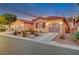 Tan colored stucco home with a 2-car garage and desert landscaping at 10290 Hawks Wing St, Las Vegas, NV 89178