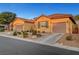 Two story home with tan colored exterior and two car garage at 10290 Hawks Wing St, Las Vegas, NV 89178