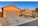 Tan colored two car garage home with desert landscaping at 10290 Hawks Wing St, Las Vegas, NV 89178