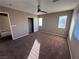 Well-lit bedroom with plush carpeting, a ceiling fan, and a sizable closet at 10488 Beckaville Ave, Las Vegas, NV 89129